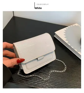 Détail du petit sac blanc pailleté avec chaîne argentée et rabat pour femme