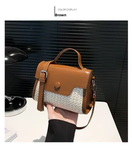 Detail view of woven straw and brown leather crossbody bag with a circular buckle