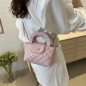 Pink quilted shoulder bag with chain strap and gold twist lock shown on a model