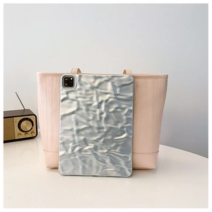 Pink tote bag with vertical pleated texture and silver tablet case for size reference