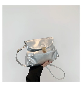 Close-up of metallic silver pleated bag with a polished golden circular clasp
