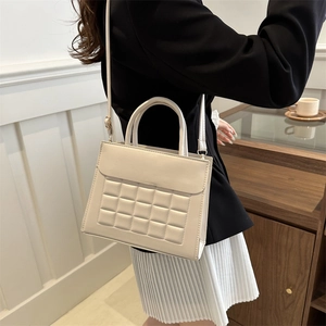 Borsa a tracolla trapuntata bianco crema con dettagli dorati su modella femminile