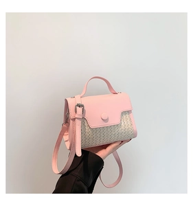 Close-up of pink leather and straw texture stitching on a mini crossbody bag