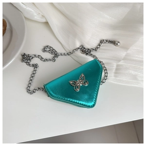Detail of blue metallic triangle mini bag with bow clasp and silver chain strap