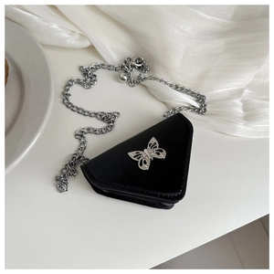 Detailed close-up of a mini triangle bag with a silver butterfly clasp and metal chain