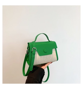 Close-up of green leather and woven straw crossbody bag with silver magnetic closure