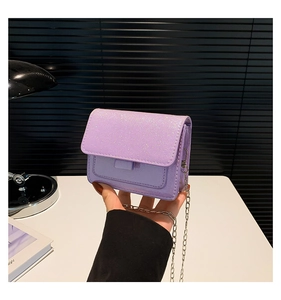 Détail du sac lilas scintillant avec chaîne argentée et texture de paillettes brillantes