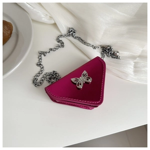 Detail of triangular metallic magenta mini bag with silver butterfly and chain strap
