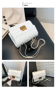 Close-up of white quilted crossbody bag with golden buckle and metal chain strap