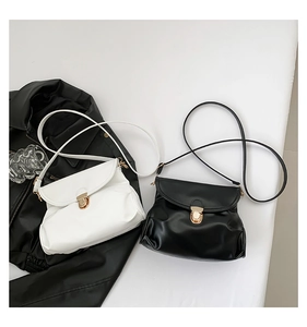 Detail view of ruched shoulder bags in black and white with gold metallic buckle