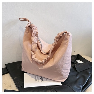 Close-up of the gathered pleated shoulder strap and nylon fabric on the pink tote bag
