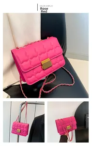 Detail of rose red quilted faux leather crossbody bag with golden metal chain and clasp
