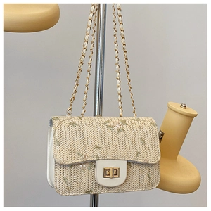 Macro shot of embroidered floral patterns and woven straw texture on this crossbody bag