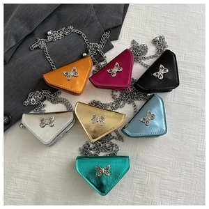 Flat lay showing multi-colored mini triangle chain bags with butterfly metal ornaments