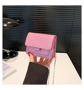 Détail du mini sac bandoulière rose pailleté avec bandoulière chaîne argentée et rabat