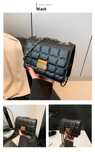 Detail of black quilted crossbody bag with golden chain strap and metallic twist lock