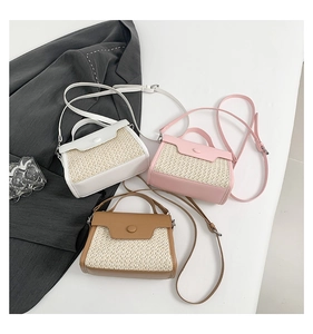 Macro shot of three small straw woven crossbody bags in white, pink and brown