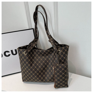 Detail of dark brown printed tote bag with matching hanging coin purse and gold hardware