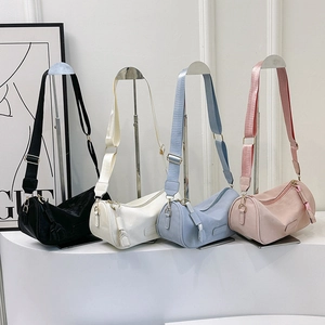 Minimalist wide strap cylinder crossbody bag in black white blue and pink PU leather