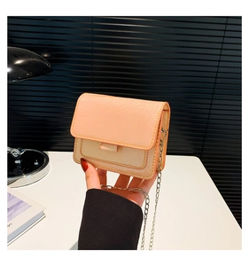 Détail du petit sac carré rose pailleté avec sa chaîne argentée et sa texture brillante