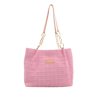 Pink tweed tote bag with woven texture, leather strap, and golden chain details