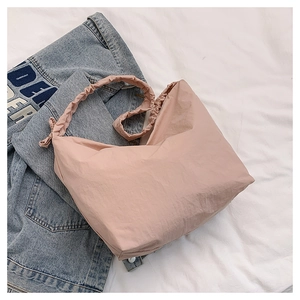 Macro detail of pink nylon cloud bag featuring drawstring pleated shoulder straps