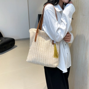 Sac fourre-tout en paille beige avec bandoulière en cuir brun et gland jaune d'été