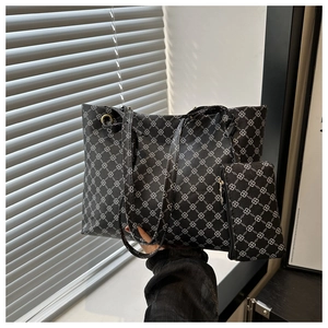 Detail of black tote bag set with geometric clover pattern and matching pouch