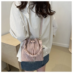 Détail du sac seau rose marbré avec poignée tressée et charmant pendentif en peluche