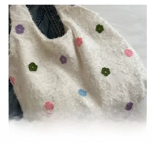 Détail de la broderie florale sur le sac en peluche avec texture de cils colorés