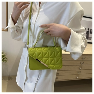 Dettaglio della borsa trapuntata verde lime con finiture dorate e tracolla a catena