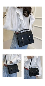 Detail view of the black PU leather satchel featuring dual buckle straps and silver rivets