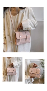 Detail view of pink leather handbag showing top handles and metal snap button straps
