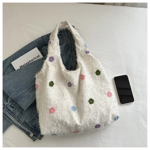 Gros plan du sac cabas en polaire blanche avec broderies florales et texture moelleuse