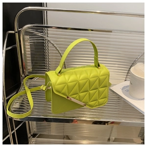 Dettaglio della borsa verde neon con motivo trapuntato geometrico e chiusura oro