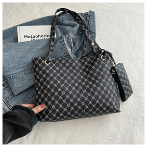 Detail of black large tote bag and matching pouch with white geometric clover patterns