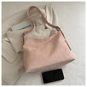 Top view of a pink textured tote bag next to a smartphone for size reference