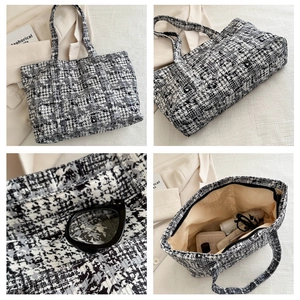 Detail view of large tweed tote bag showing woven texture, interior and zipper closure
