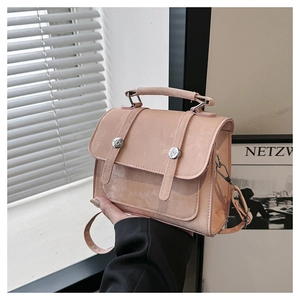 Detail of light pink mini satchel with top handle and silver metal accents