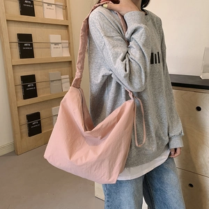 Pink pleated nylon hobo bag with wide shoulder strap and spacious minimalist design