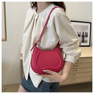 Detail of hot pink hobo bag featuring 3D U-shaped texture and sleek leather strap