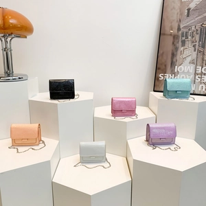 Mini sacs bandoulière vernis aux tons macarons avec chaîne sur des supports géométriques