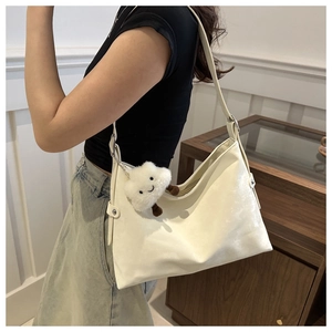 Close-up of cream white PU leather Hobo bag with a cute cloud plush charm detail