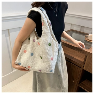 Détail d'un sac cabas en fausse fourrure blanche avec motifs floraux et large bandoulière