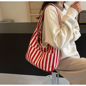 Close-up of red and white striped canvas tote bag showing side pocket and durable texture