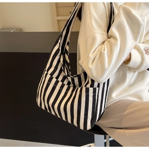 Close-up of black and white striped canvas tote bag showing side pocket detail