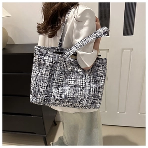 Detailed back view of a large houndstooth tote bag worn over the shoulder for daily use