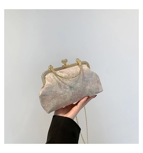 Close-up of vintage floral jacquard fabric and metal spherical clasp on the clutch bag