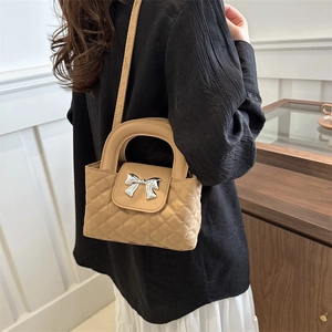 Quilted crossbody bag with silver bow hardware and top handle in beige PU leather