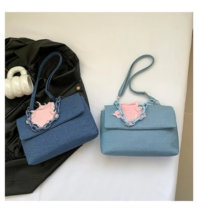 Macro view of denim flap bags featuring pink star patchwork and chunky plastic chains